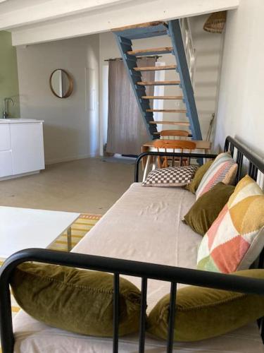 un lit avec des oreillers dessus dans une chambre dans l'établissement Le joli studio bleu & vert de St Pierre, à Saint-Pierre-dʼAurillac