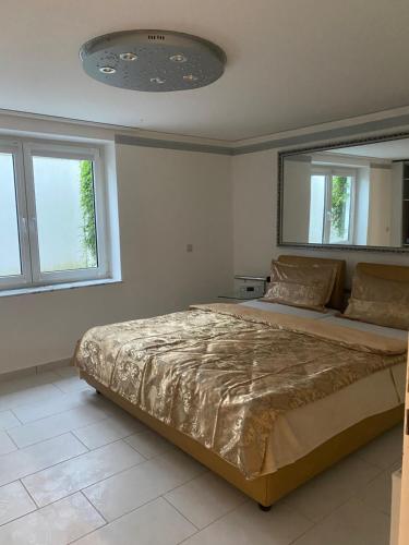 Un dormitorio con una cama grande en una habitación con ventanas. en Garten Eden, en Geisbach