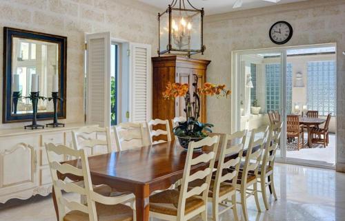 a dining room with a wooden table and chairs at Ocean Mist Villa 4Bd by ZenBreak in Saint Philip