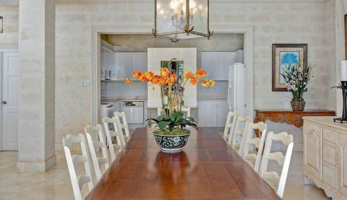 a kitchen with a table with a vase of flowers on it at Ocean Mist Villa 4Bd by ZenBreak in Saint Philip