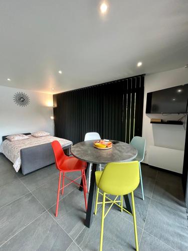 une pièce avec une table, des chaises et un lit dans l'établissement Charmant logement, à Choignes