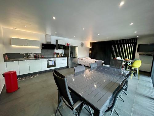 une cuisine et un salon avec une table et des chaises dans l'établissement Charmant logement, à Choignes