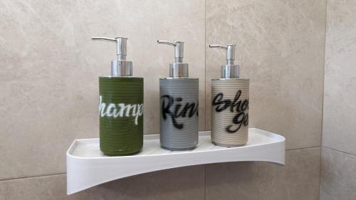 three water bottles sitting on a shelf in a bathroom at Garden House Puerto López in Puerto López