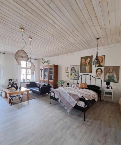 a bedroom with a bed and a living room at Apartament w Fabryce Czekolady in Bytom