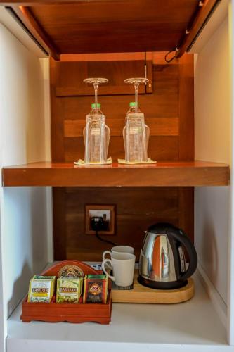 a shelf with two glass jars and a tea kettle at Grand Serendib Hotel in Kandy