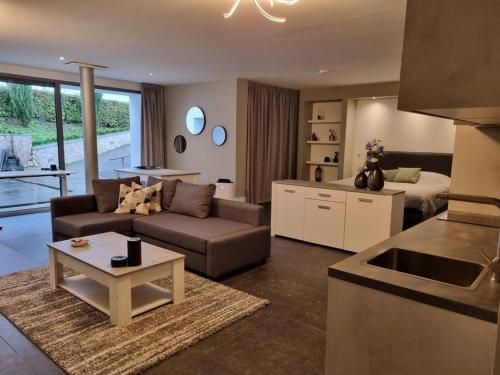a living room with a couch and a table and a kitchen at Zuiderlijk Genieten in Heerlen