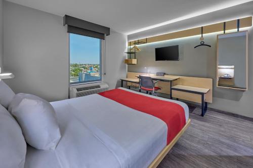 a hotel room with a large bed and a desk at City Express by Marriott Mexicali in Mexicali