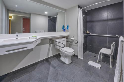 a bathroom with a toilet and a sink and a shower at City Express by Marriott Mexicali in Mexicali