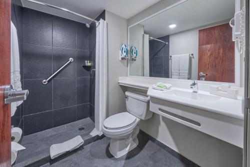 a bathroom with a toilet and a sink and a shower at City Express by Marriott Mexicali in Mexicali