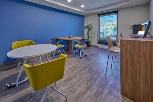 an office with two tables and chairs and a blue wall at City Express by Marriott Mexicali in Mexicali