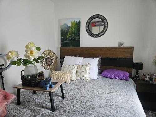 a bedroom with a bed with a table and flowers at De Pearl Home Tatu City - Nairobi in Nairobi