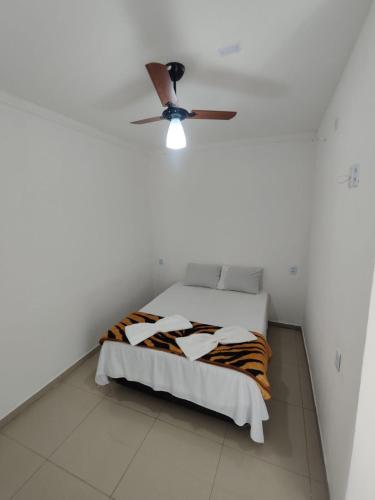 a bedroom with a bed with a ceiling fan at Olegário Bueno 230 in Hortolândia