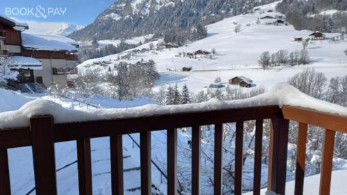 a snow covered balcony with a view of a mountain at Chalets des Evettes- appartement vue montagne in Flumet