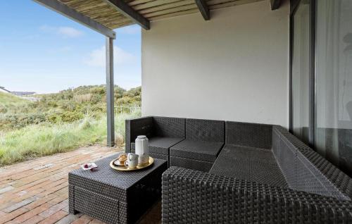 a black couch sitting on a patio with a table at Awesome Home In Thisted With Sauna in Thisted