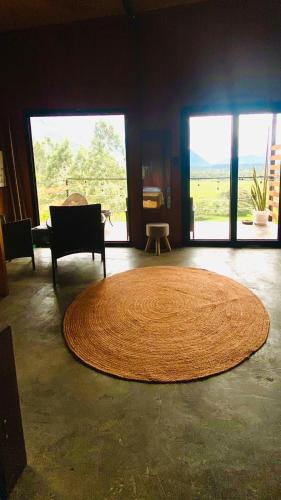 a large rug on the floor in a room with windows at Cabaña1 con hermosa vista al valle in Oxapampa
