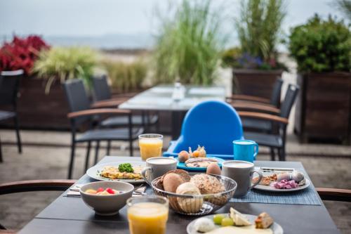 博尔滕哈根BEECH Resort Boltenhagen的餐桌上放有食物和橙汁