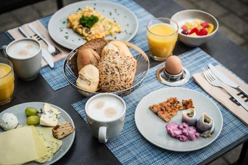 博尔滕哈根BEECH Resort Boltenhagen的桌子上摆着几盘面包、鸡蛋和饮料。