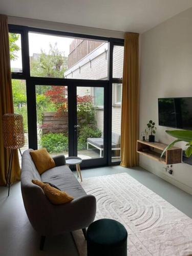 a living room with a couch and a large window at Luxurious appartement with sauna and kitchen in center of Dordrecht in Dordrecht