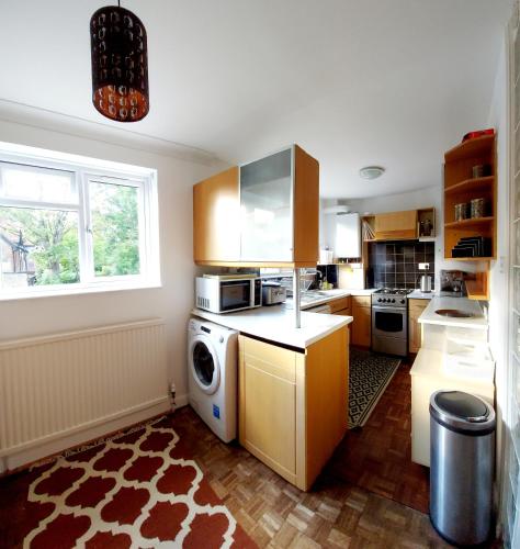a kitchen with a washer and dryer in it at Oriental, 2 Double Bedroom Flat, Royal Greenwich, SE London in London