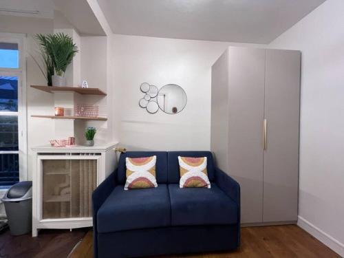 un salon avec un canapé bleu et une cheminée dans l'établissement Trocadéro Eiffel Tour - refurbished furnished flat, à Paris