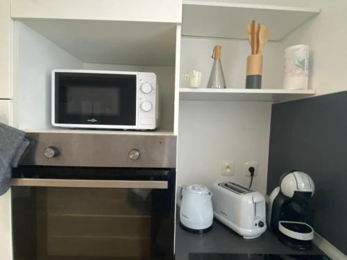 a microwave sitting on top of a kitchen counter at Prox centre, beau T3, 2 ch, 7 personnes in Brest