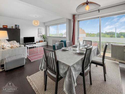 d'une salle à manger avec une table et des chaises dans le salon. dans l'établissement Vue dégagée, Cuisine moderne et WIFI, à Strasbourg