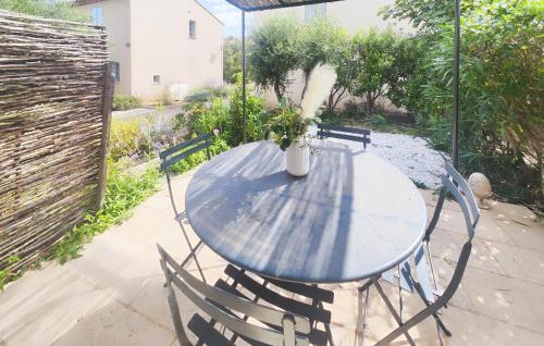 une table et des chaises bleues avec un vase. dans l'établissement Lovely Home In Saint-Laurent-De-La-Ca, à Saint-Laurent-de-la-Cabrerisse