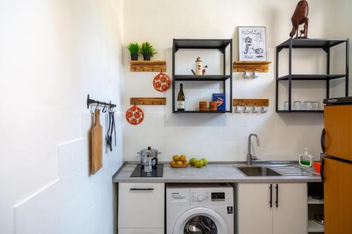 a kitchen with a sink and a washing machine at La casa di Nina in Monte di Procida