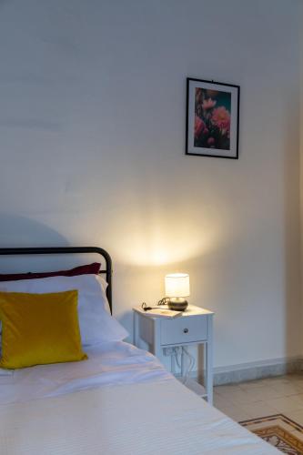 a bedroom with a bed and a table with a lamp at La casa di Nina in Monte di Procida