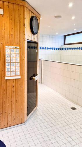an empty bathroom with a clock on the wall at Le Petit- Niedliches Ferienapartment mit Pool in Schluchsee