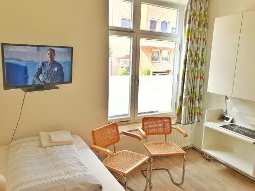 a small room with a bed and a tv on the wall at Aparthotel B & L in Bremen