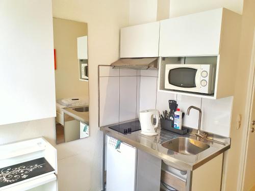 a small kitchen with a sink and a microwave at Aparthotel B & L in Bremen