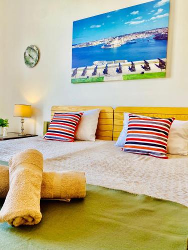 une chambre avec un grand lit avec deux oreillers dans l'établissement Spinola Shoreline Homestay St Julians, à San Ġiljan