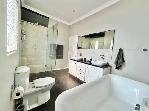a bathroom with a tub and a toilet and a shower at Beach House Princes Grant Golf Estate in Blythedale