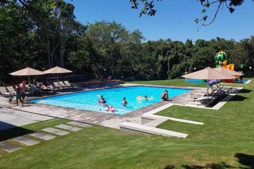 a group of people swimming in a swimming pool at Beach House Princes Grant Golf Estate in Blythedale