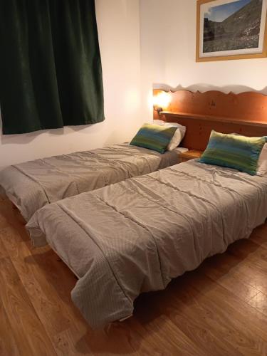 two beds sitting next to each other in a room at Chamrousse 1700 - Les Villages du Bachat - Silènes C23 - Classé 3 étoiles in Chamrousse