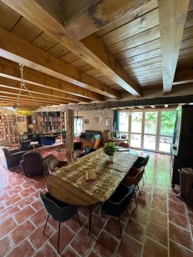 Großes Zimmer mit einem Holztisch und Stühlen. in der Unterkunft Domaine Les Belles Fontaines in Bierry-les-Belles-Fontaines