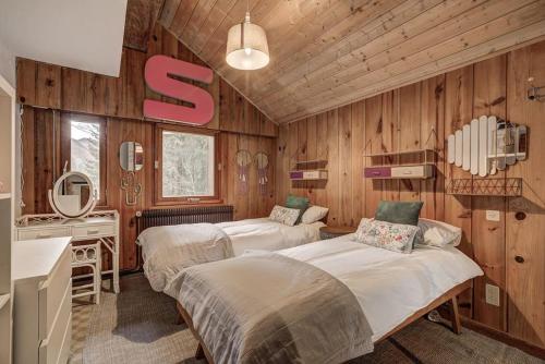 - une chambre avec 2 lits dans une pièce dotée de murs en bois dans l'établissement Large peaceful chalet for mountain adventures! Perfect for Flégère and Grand Montet skiing, à Chamonix-Mont-Blanc