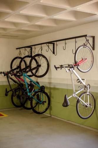 two bikes hanging on a wall in a garage at Studio moderno com garagem no kobrasol in São José