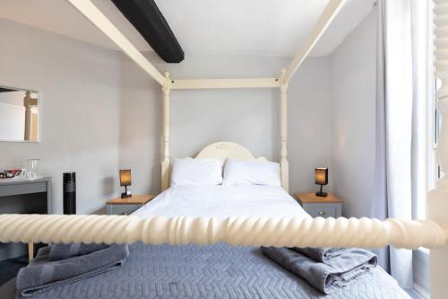 a bedroom with a white bed with two lamps at The Court in Bridgnorth