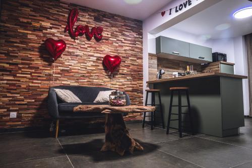 Cette chambre dispose d'un canapé et d'un mur en briques avec le cœur. dans l'établissement Évasion room spa, à Hénin-Beaumont