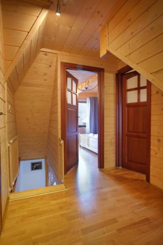 an empty room with a staircase in a wooden house at Domki JAWOR in Zakopane