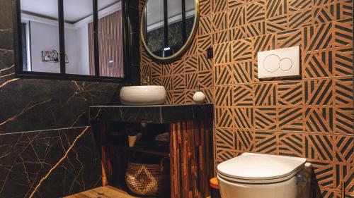 une salle de bain avec toilettes et miroir dans l'établissement Évasion room spa, à Hénin-Beaumont