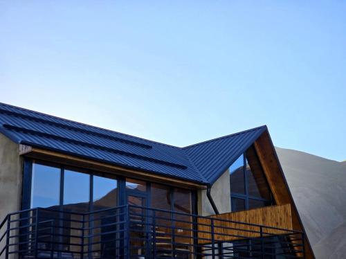 a house with a solar roof on top of it at Grand Mountain Cottage in Stepantsminda