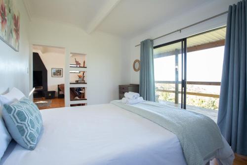 a bedroom with a large bed with a large window at Bo-den-See Cottage in Groot Brak Rivier