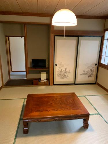 a wooden coffee table in a room with windows at 旅宿景雅 in Yamanakako