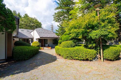 a house with hedges in front of a yard at 旅宿景雅 in Yamanakako