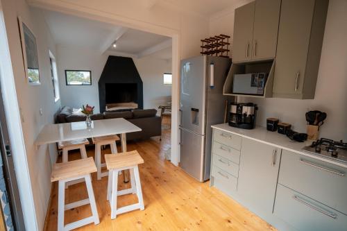 a kitchen and living room with a table and chairs at Bo-den-See Cottage in Groot Brak Rivier