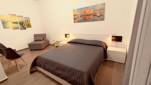 a bedroom with a large bed and a chair at La Perla del sur in Bari