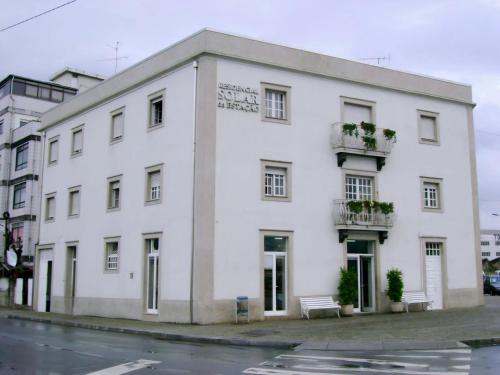 a white building on the side of a street at Residencial Solar da Estação in Barcelos